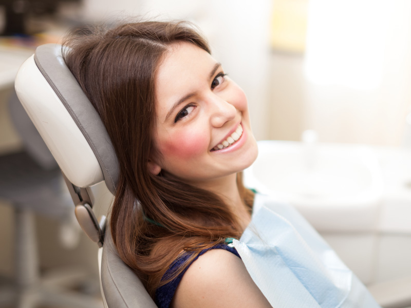 Services-WhiteFillings Smiling woman in the dentist's chair